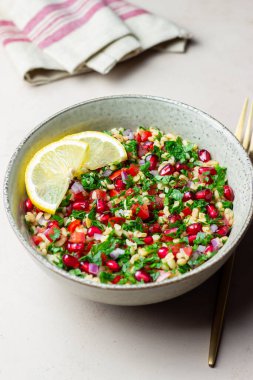 Bulgur, nane, maydanoz, domates ve nar içeren Tabbouleh salatası. Sağlıklı beslenme. Vejetaryen yemeği.