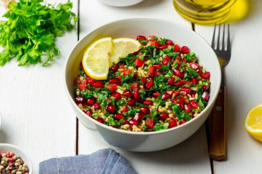 Bulgur, nane, maydanoz, domates ve nar içeren Tabbouleh salatası. Sağlıklı beslenme. Vejetaryen yemeği.