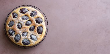 Pembe arka planda erik turtası. Pişirme. Vejetaryen yemeği.