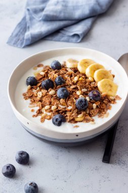 Yoğurtlu granola, yabanmersini, fındık, muz ve bal. Müsli. Sağlıklı beslenme. Vejetaryen yemeği.