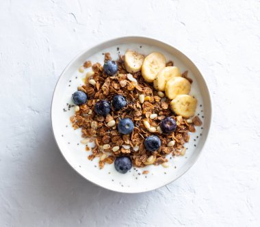 Yoğurtlu granola, yabanmersini, fındık, muz ve bal. Müsli. Sağlıklı beslenme. Vejetaryen yemeği.
