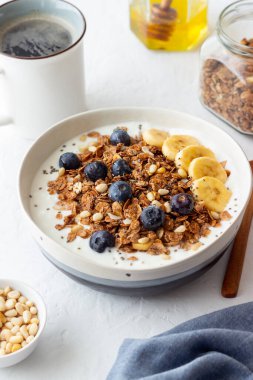 Yoğurtlu granola, yabanmersini, fındık, muz ve bal. Müsli. Sağlıklı beslenme. Vejetaryen yemeği.