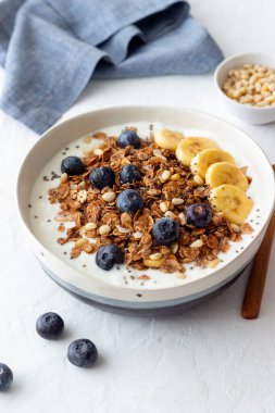 Yoğurtlu granola, yabanmersini, fındık, muz ve bal. Müsli. Sağlıklı beslenme. Vejetaryen yemeği.
