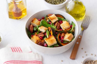 Balkabaklı salata, nar, ceviz ve kızarmış ekmek. Sağlıklı beslenme. Vejetaryen yemeği.