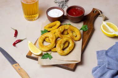 İki soslu kızarmış kalamar halkaları, limon ve otlar. Fast food. Aperatif