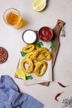 İki soslu kızarmış kalamar halkaları, limon ve otlar. Fast food. Aperatif