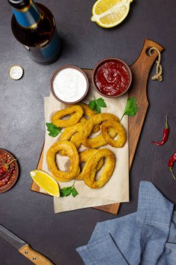 İki soslu kızarmış kalamar halkaları, limon ve otlar. Fast food. Aperatif