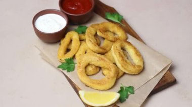 İki soslu kızarmış kalamar halkaları, limon ve otlar. Fast food. Aperatif.