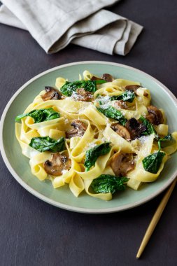 Mantarlı makarna, ıspanak ve peynir. Sağlıklı beslenme. Vejetaryen yemeği. İtalyan mutfağı