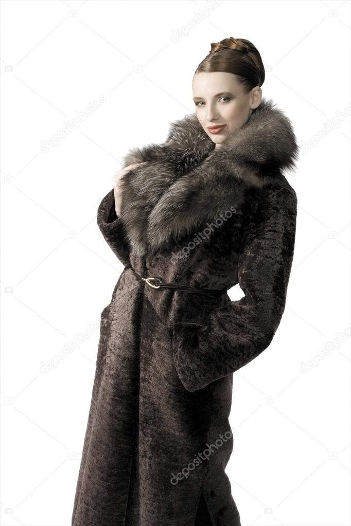 Beautiful blond model girl in fur coat on the city background