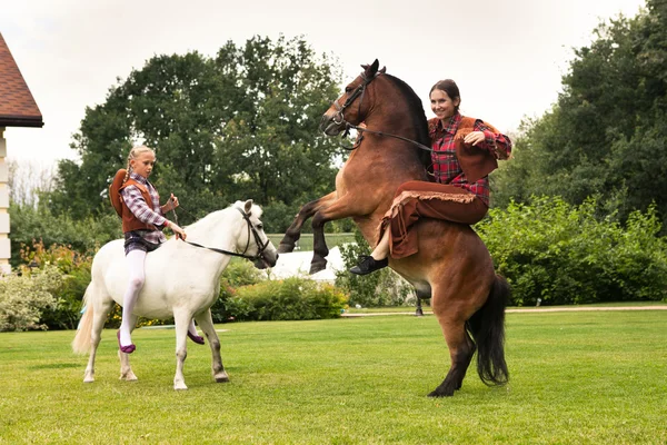 Duas meninas equitação pônei — Fotografia de Stock