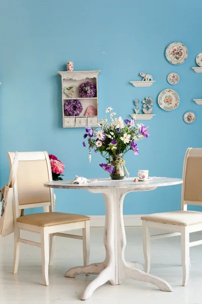 Interior da sala de jantar com flores placas decorativas parede azul e — Fotografia de Stock