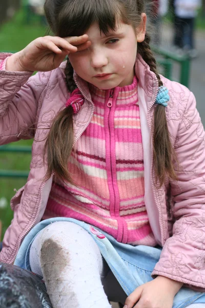 Preteen little girl with long dark hair cry because she hurt her leg — Stock Photo, Image