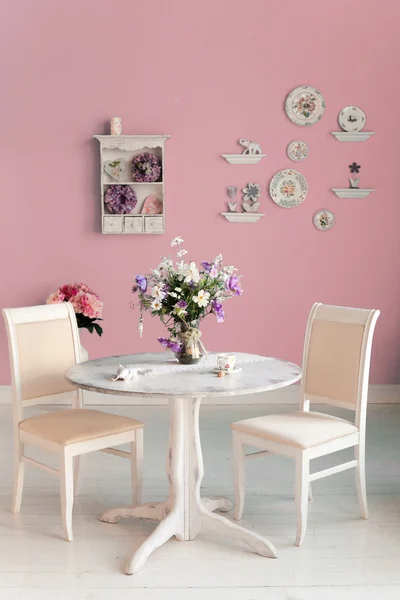 Sala da pranzo interno con fiori decorativi piatti parete blu un — Foto Stock