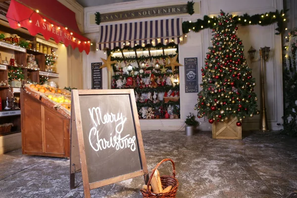 Julgran i xmas dekorerad stad fragment med souvenirbutik, café och konfektyr butik Stockbild