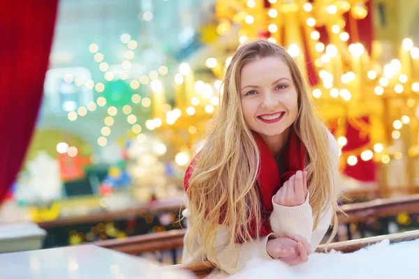 Boldog szőke lány piros sállal közelkép portré díszített karácsonyi város háttér — Stock Fotó