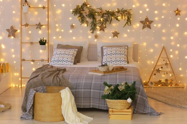 Dormitorio decorado de Navidad con guirnaldas, estrellas, árbol de Navidad, escalera, regalos y cama de cerca foto — Foto de Stock
