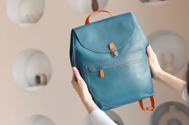 Mavi deri sırt çantası. İnsan eliyle yakın plan fotoğraf. Fotoğrafı kapat.