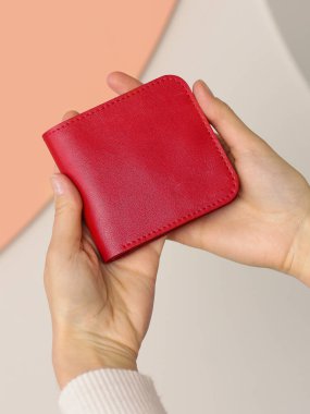 kırmızı deri çanta insan eliyle kapatılmış fotoğraf.