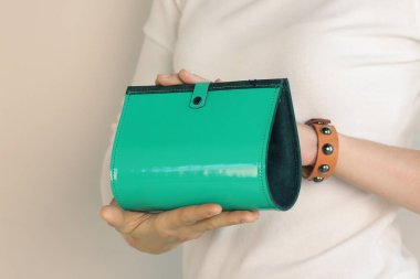 Yeşil deri çantalı, insan eliyle çekilmiş bir fotoğraf.