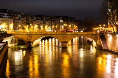 Gece Paris, Pont au Change, Seine nehrinin yansıması, şehir manzarası.