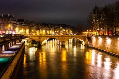 Gece Paris, Pont au Change, Seine nehrinin yansıması, şehir manzarası.