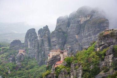 Yunanistan 'da meteora, dağların arka planında manastır, bulutlu gökyüzü