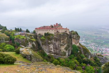 Yunanistan 'da meteora, dağların arka planında manastır, bulutlu gökyüzü