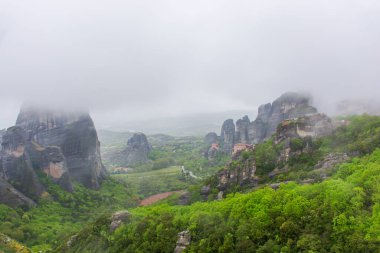 Yunanistan 'da meteora, dağların arka planında manastır, bulutlu gökyüzü