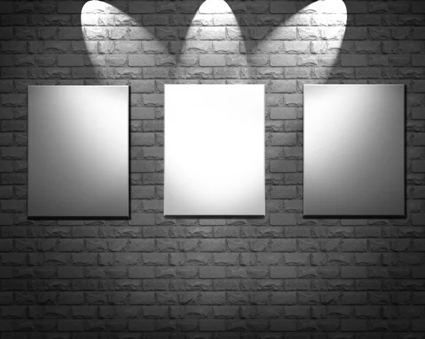 Порожні рамки на кам'яній стіні освітлені точкові світильники — стокове фото