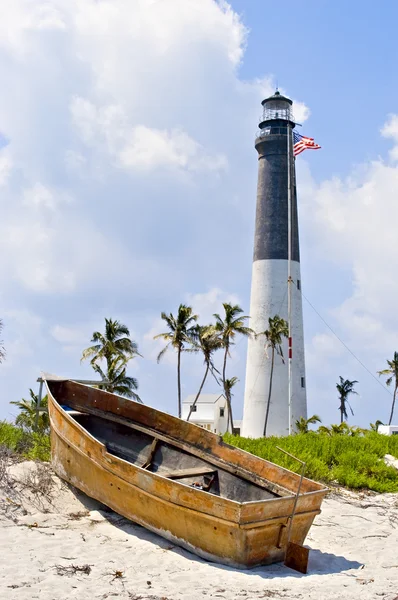 Lighthouse, flag and boat — Stock Photo, Image