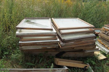 Eski ahşap çerçeve çöp Kırık cam ile doğada yeşil çimenler içinde bir yığın