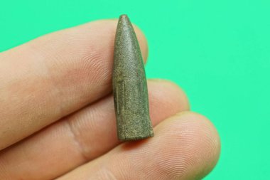 Yeşil arka planda bir gri askeri kurşun var.