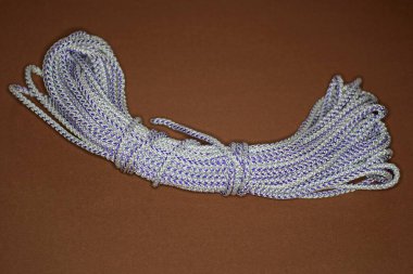 Kahverengi bir masanın üzerinde beyaz bir ip var.