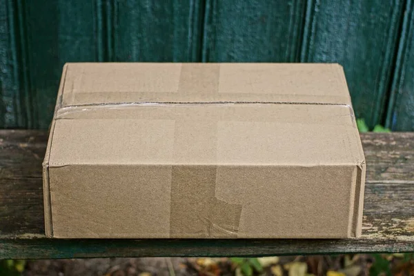Одна Коричнева Картонна Коробка Паперу Лежить Сірому Столі Зеленій Стіні — стокове фото
