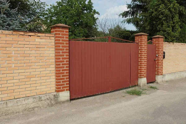 Красные Металлические Ворота Закрытая Дверь Стене Коричневого Кирпичного Забора Улице — стоковое фото
