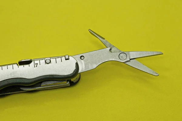 One Small Gray Scissors Metal Multitool Lies Yellow Table — Stock Photo, Image
