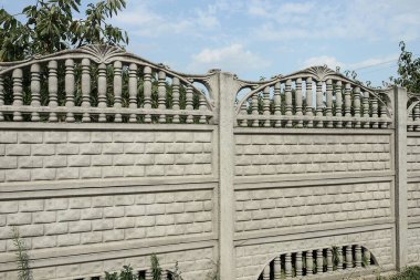 Yeşil bitki örtüsünde, kırsal bir sokakta gri beton duvarın bir parçası.