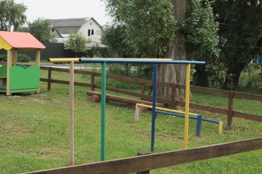 Spor sahasında yeşil çimlerde renkli metal barlar.