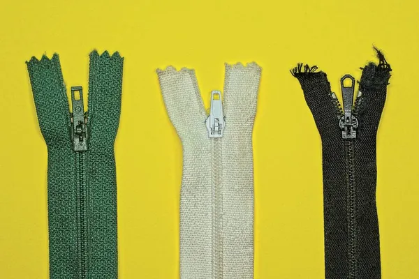 Três Tiras Tecido Coloridas Com Zíperes Metal Estão Uma Mesa — Fotografia de Stock