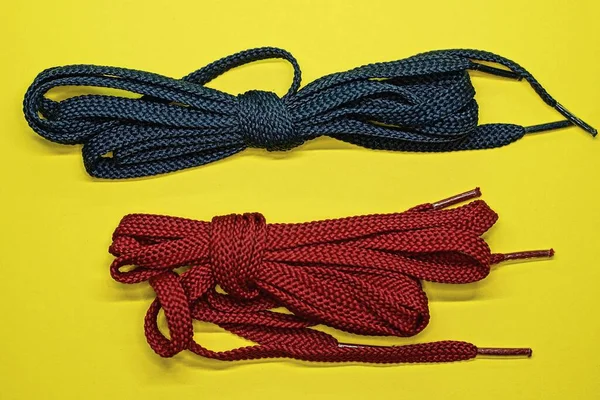 Two Skeins Red Blue Laces Lie Yellow Table — Stock Photo, Image