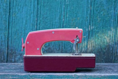 Eski kırmızı bir oyuncak araba gri bir masanın üzerinde duruyor yeşil ahşap bir duvara karşı