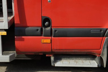 Siyah kapalı bir benzin deposu olan kırmızı bir arabanın parçası.