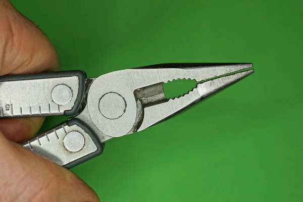 Hand Houdt Grijze Metalen Tang Multitool Groene Achtergrond — Stockfoto