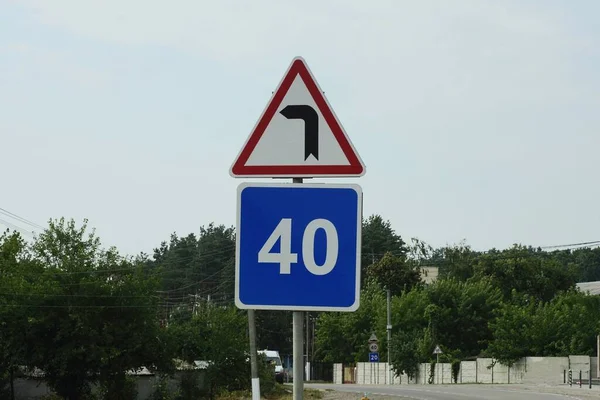 Два Дорожні Знаки Небезпечний Поворот Обмеження Швидкості Стовпі Вулиці Тлі — стокове фото