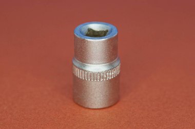 Bir gri metal baş silindir adaptörünün aracı kahverengi bir masanın üzerinde duruyor