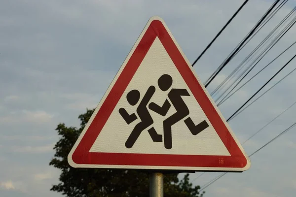 Een Driehoekig Bord Waarschuwing Kinderen Straat Tegen Grijze Lucht Achtergrond — Stockfoto