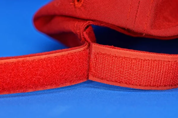 red sticky harness the buckle on the cap lies on the blue table