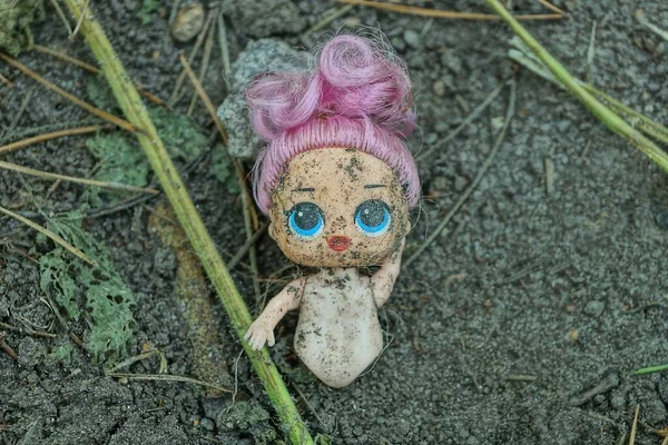 古い汚れたプラスチック製のおもちゃの人形が通りの灰色の地面にあり — ストック写真