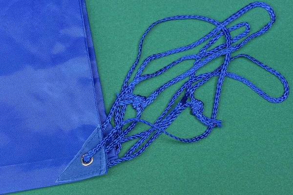 緑のテーブルの上のバックパック生地にグレーの金属製のリングの青いロープレース — ストック写真